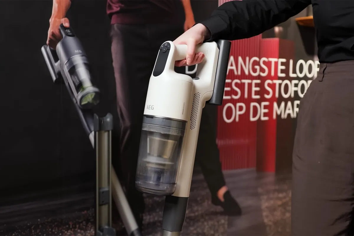 Persoon houdt de AEG 9000 steelstofzuiger vast.