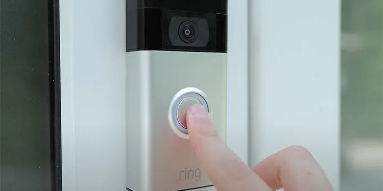 Ring videodeurbel aan de deurpost wordt ingedrukt met wijsvinger