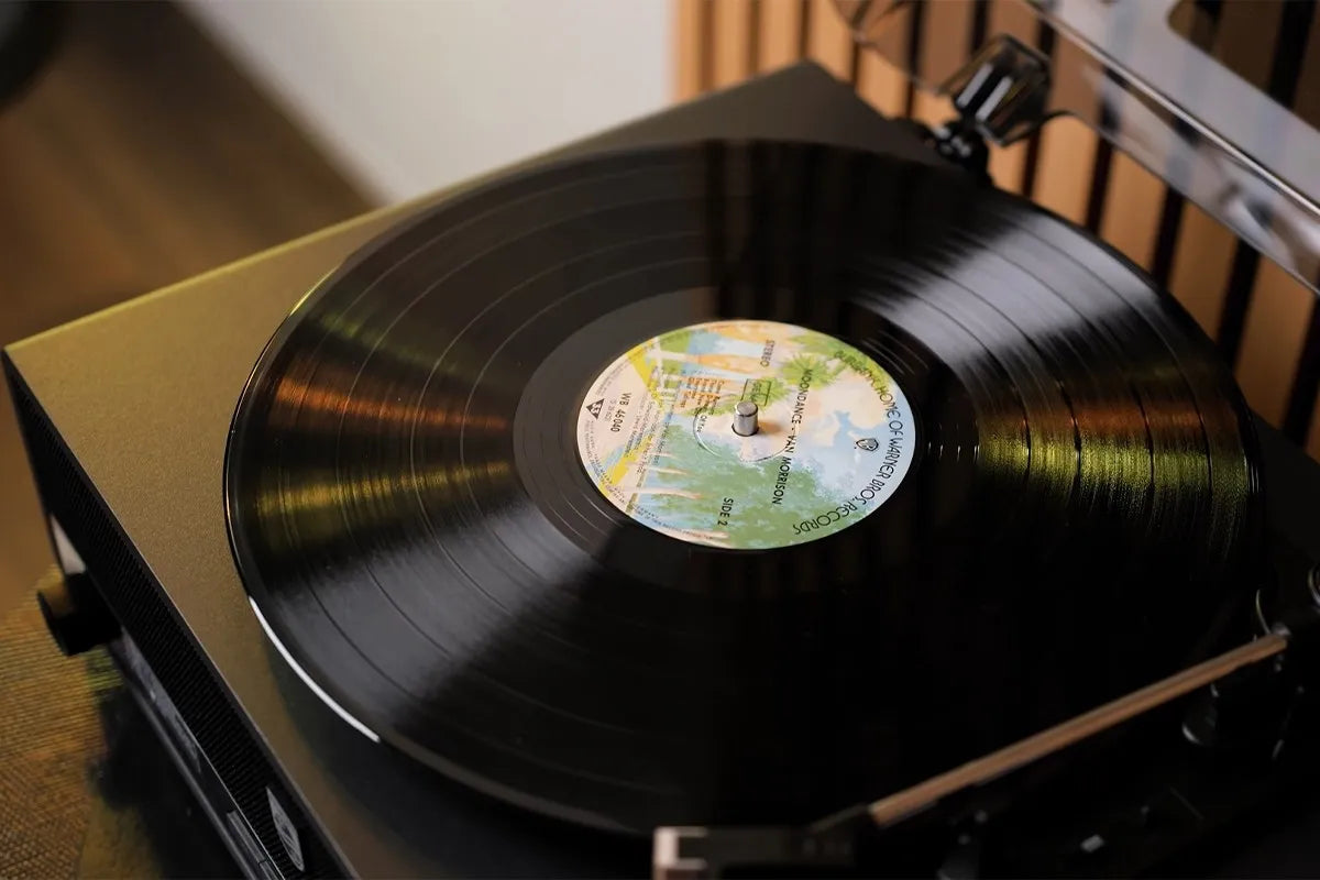 Close-up van een zwarte vinylplaat die draait op de Philips The Stevie, waarbij het middenlabel met kleurrijke opdruk goed zichtbaar is en de toonarm net boven de rand van de plaat hangt.