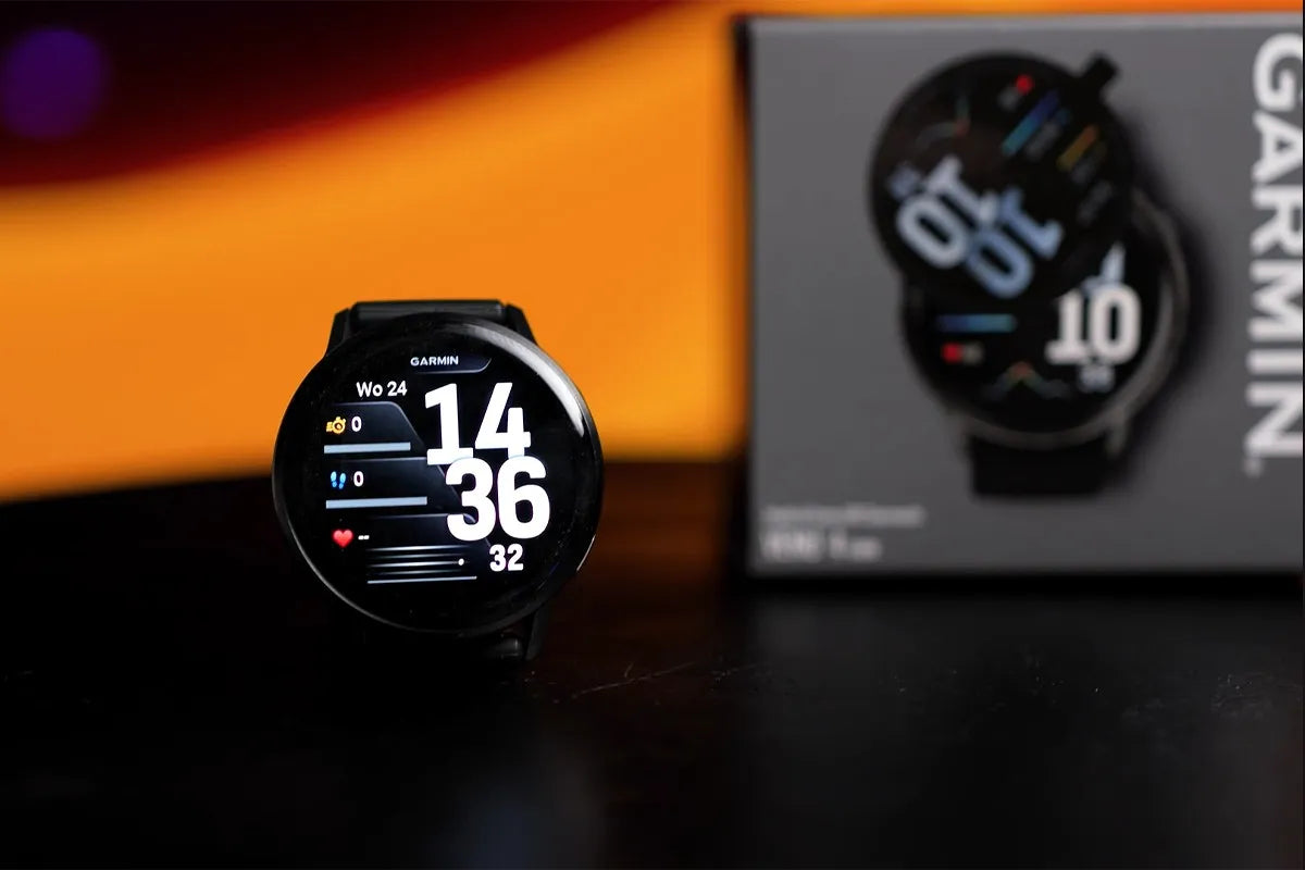 Close-up van de Garmin Venu 4 met in de achtergrond de verpakking van het product.