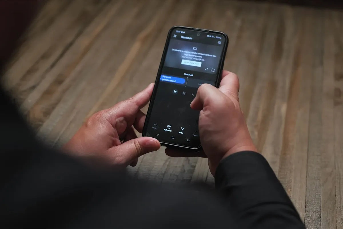 Persoon bedient videodeurbel vanuit de app op zijn telefoon