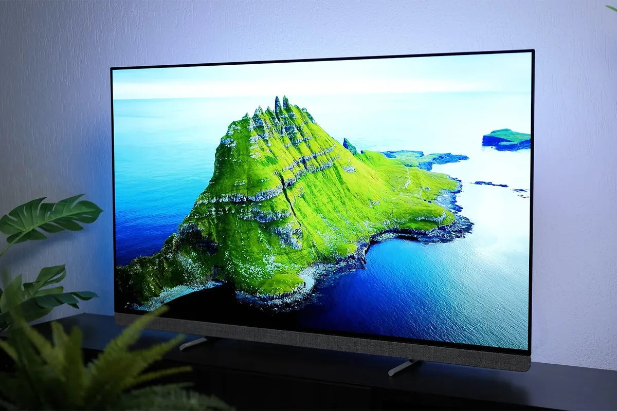 Philips OLED+ tv waarop een haarscherp groen eiland wordt weergegeven met opvallende rotspartijen dat omgeven is door helderblauw water.