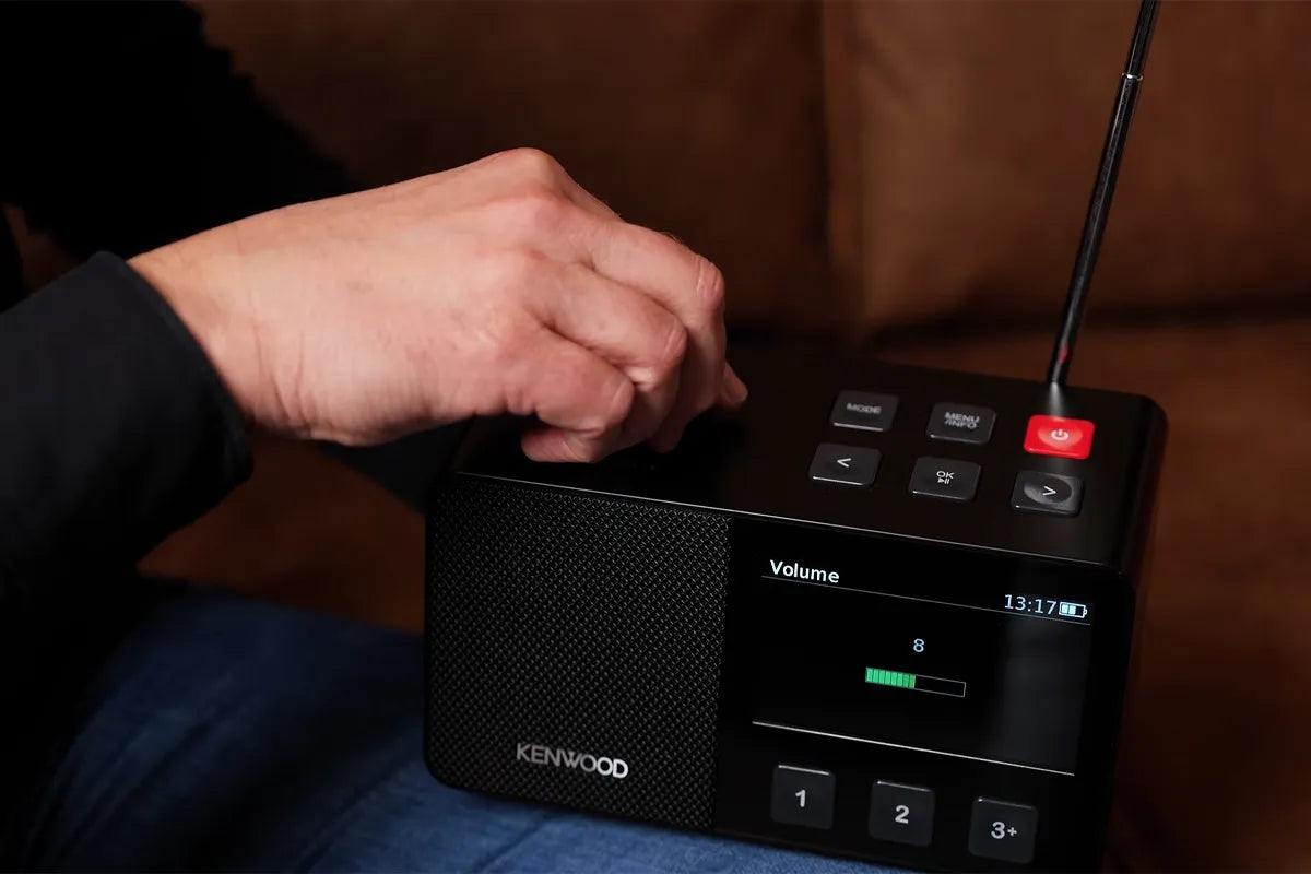 Persoon draait aan de volumeknop van de Kenwood CR-M70DAB