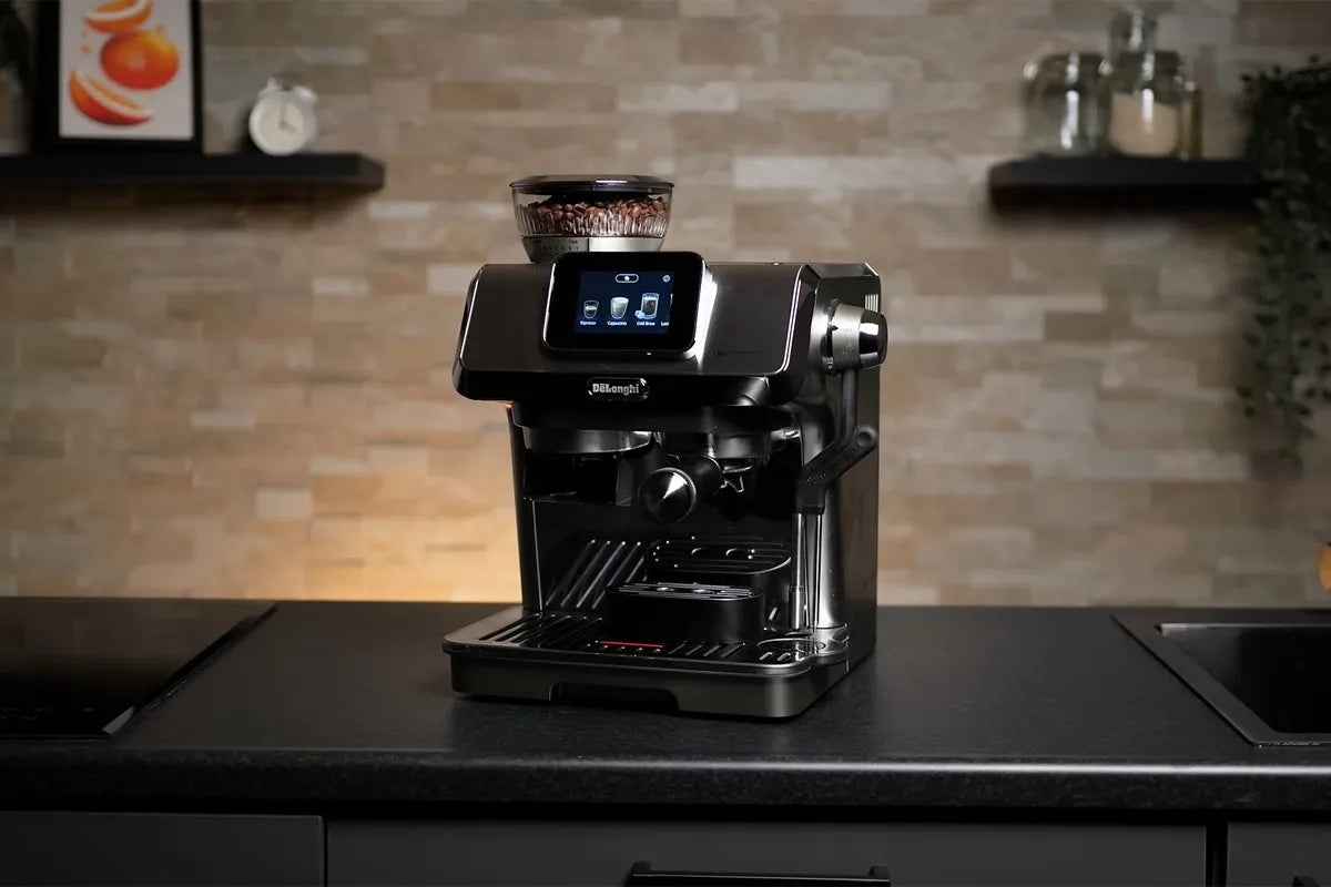 De'Longhi La Specialista Touch espressomachine die op een donker keukenblad staat in een moderne keuken met een lichte stenen achterwand