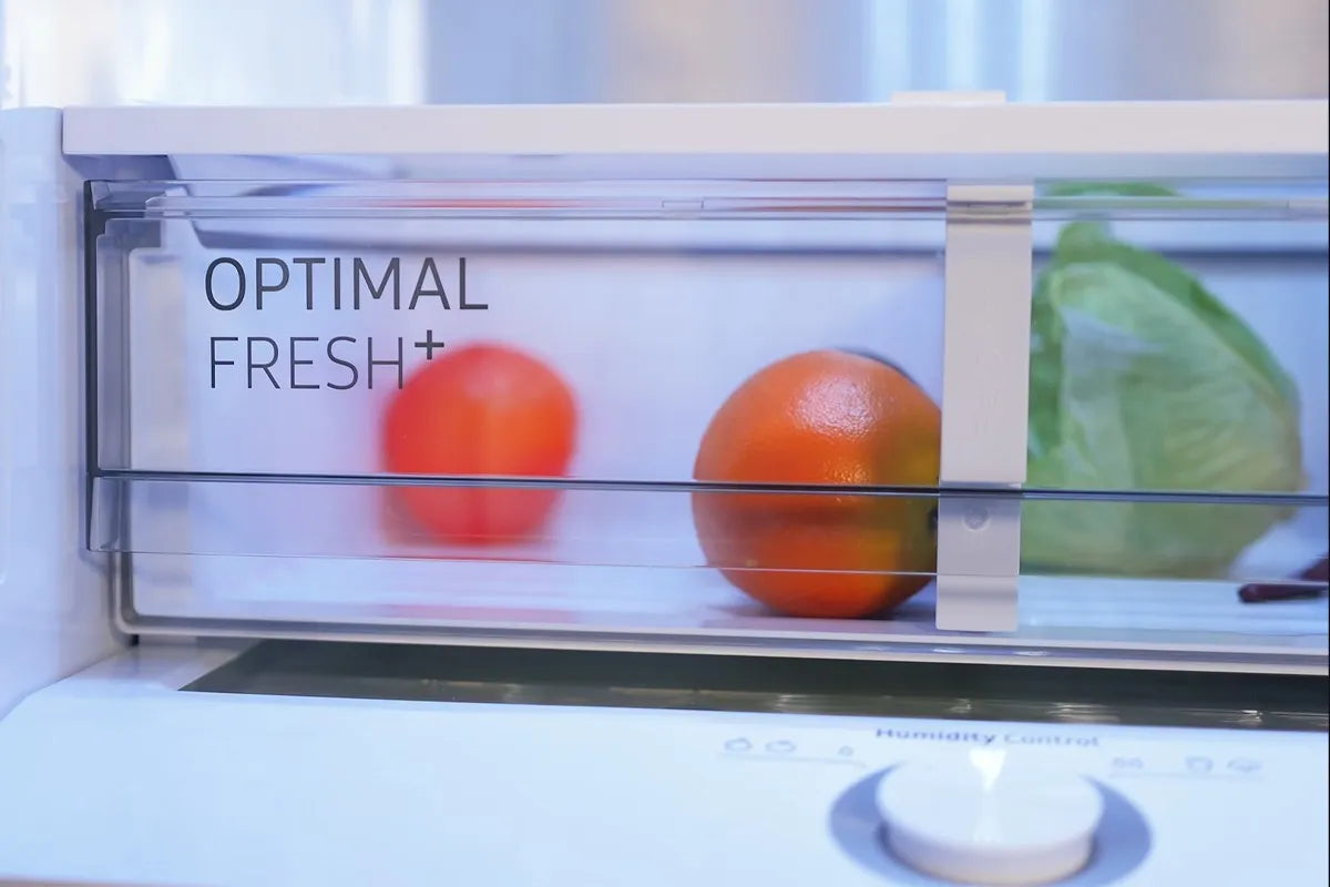 Close-up van de Optimal Fresh Plus lade gevuld met sinaasappelen en een krop sla.