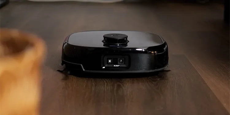 De Eufy Omni E28 rijdt over een donker houten vloer. Aan de voorzijde is een dubbele camera zichtbaar
